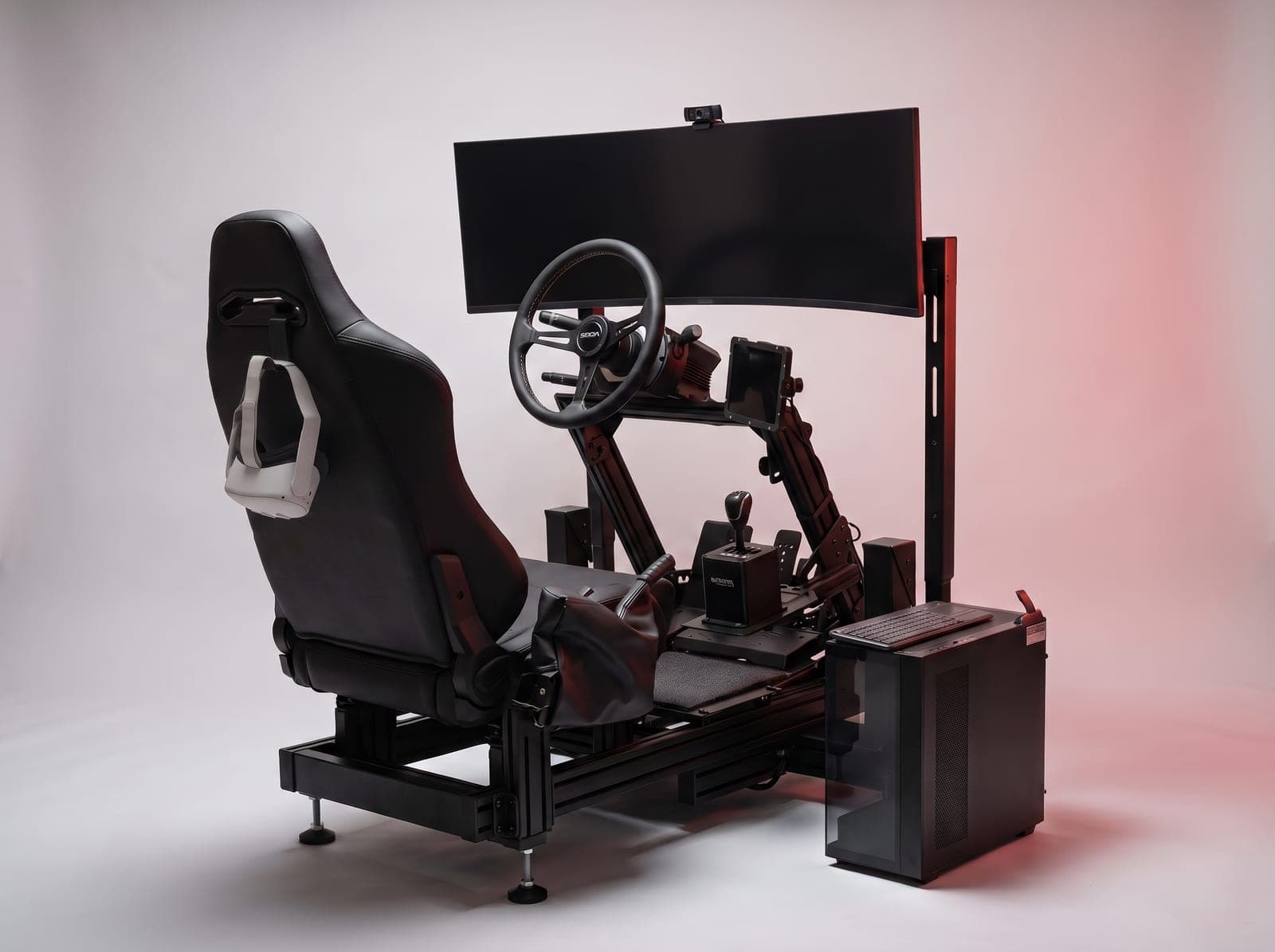 Řidičský trenažér AUTOM TR4 se sedačkou, VR brýlemi, volantem, tabletem a zakřiveným monitorem ve studiu